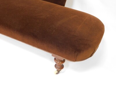 A Victorian mahogany chaise longue, upholstered in brown velour, raised on turned legs, brass capped on castors, 192cm wide. - 4