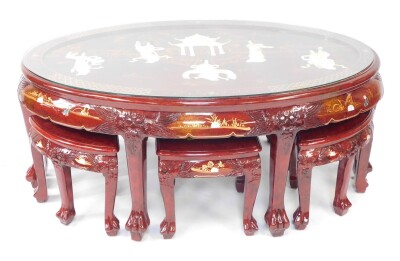 A Chinese red lacquer and 'Shibyama' oval coffee table, decorated with figures and pagodas in a garden setting, raised on six tapering square legs and lion's paw feet, 52cm high, 120cm wide, 77cm deep., together with a Chinese red lacquer and Shibyama set