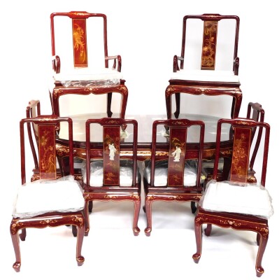 A Chinese red lacquer and 'Shibyama' dining suite, decorated with figures in a garden, flowers and geometric motifs, the table of oval form, raised on cabriole legs, 78cm high, 184cm wide, 106cm deep, together with eight dining chairs, with loose cushion