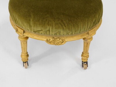 A Victorian parcel gilt balloon back nursing chair, upholstered in green button back velour with over stuffed seat, raised on turned and fluted legs, on ceramic castors. - 3