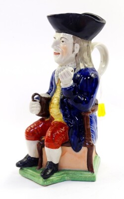 A late 19thC Sampson character jug modeled as The Squire, pipe lacking, modeled seated on a triform base, 27cm high. - 2