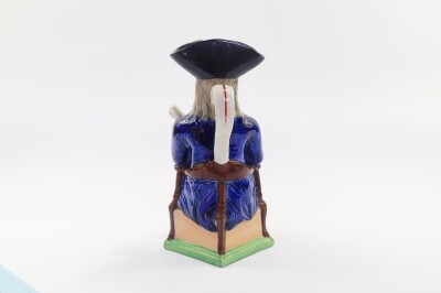 A late 19thC Sampson character jug modeled as The Squire, pipe lacking, modeled seated on a triform base, 27cm high. - 3