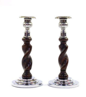A pair of Art Deco oak and chrome candlesticks, of spiral fluted form, raised on stepped circular bases, 21.5cm high.