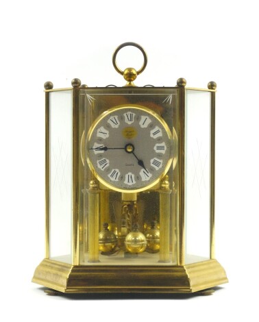 A German brass cased 400 day anniversary clock, for Rapport of London, circular silvered dial bearing Roman numerals, PPB Quartz movement, No 2732667., the case of hexagonal form, with engraved glass side panels, raised on circular screw feet, 26cm high.