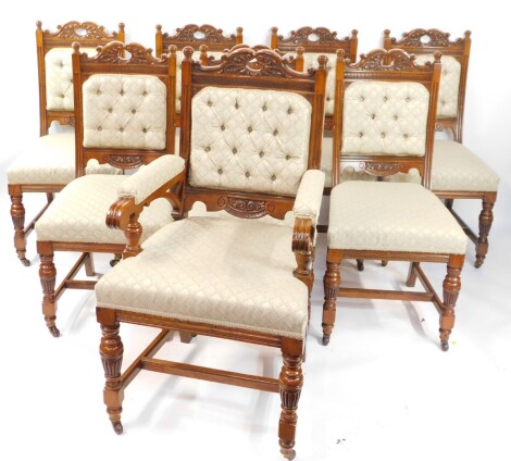 A set of eight Victorian oak dining chairs, with carved crest rails, button backs and over stuffed seats, raised on fluted and turned legs united by an H framed stretcher, comprising a carver and seven single chairs.