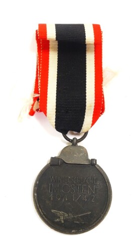 A Third Reich Wehrmacht Eastern Medal, obverse the eagle and Swastika, reverse Winterschacht Imosten 1941/42., with ribbon.