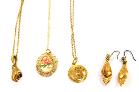 A 9ct gold circular pendant on chain, 9ct gold and sapphire pendant, formed as a hand holding a bud, on chain, a plaque painted with a rose in a pendant mount on chain, stamped 9ct, and a pair of foiled yellow metal earrings, 7.7g all in.