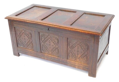 An 17thC oak blanket box, with a carved triple panelled front, raised on channeled square legs, 55cm high, 122cm wide, 59.5cm deep.