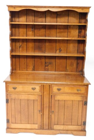 An 18thC style oak dresser, of small proportion, the moulded cornice above a shaped frieze and three Delft racks, with two frieze drawers and double cupboard beneath, 180cm high, 121cm wide, 49cm deep.