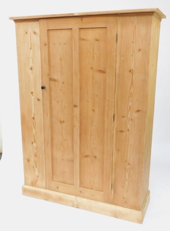 A Victorian pine hall cupboard, single door opening to reveal a shelf and hanging hooks, raised on a plinth base, 185cm high, 136cm wide, 44.5cm deep.