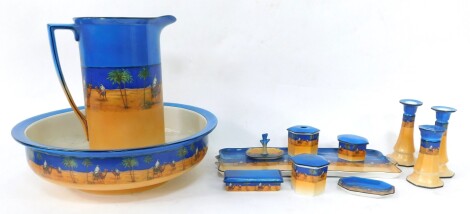 An Oxford pottery wash jug and bowl, decorated with a Bedouin scene, and a matching dressing table set, comprising twin handled tray, pair of candle holders, hat pin holder, three boxes and cover, hair tidy, pin tray and a ring tree.