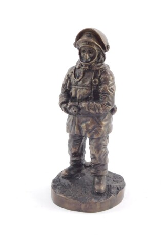 A bronzed plaster figure of a fireman, modeled in standing pose, in full gear, marked 97AGP, 26cm high.