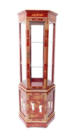 A Chinese red lacquer and 'Shibyama' display cabinet, of hexagonal form, the pediment over an upper glass panelled section with single door enclosing two glass shelves, above a panelled base section decorated with figures, with single door, raised on brac