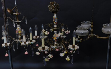 A Continental 20thC porcelain and brass six branch chandelier, encrusted with flowers, with two tears of porcelain floral and amethyst cut glass drops, 61cm high, and another similar five branch chandelier, 40cm high, and a brass three branch ceiling ligh