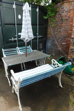 A white painted and cast iron and wooden slatted garden set, comprising a two seater bench, 126cm wide, a pair of armchairs, table 65cm high, 140.5cm wide, 68cm deep, a parasol and parasol stand. (6)