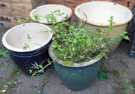 A pair of graduated green glazed stoneware flower pots, 33cm high, a blue glaze flower pot 33cm high, and a further flower pot containing mint, 31.5cm high. (4)