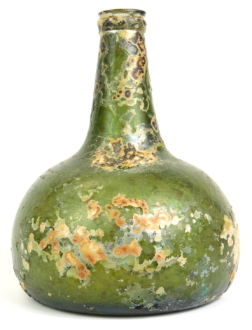 An 18thC green glass onion shaped wine bottle, signs of excavation, 19cm high.