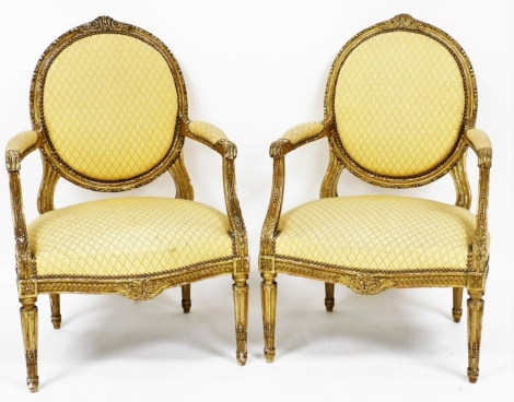 A pair of early 19thC French style gilt painted fauteils, each with a yellow diamond upholstered back and seat, with button surround, on carved frieze and tapered legs and supports (AF), 103cm high, 62cm wide, 58cm deep.