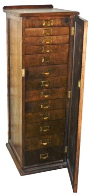 An oak ply collectors cabinet, with an arrangement of thirteen numbered drawers behind single door, 116cm high, 40cm wide, 46cm deep.