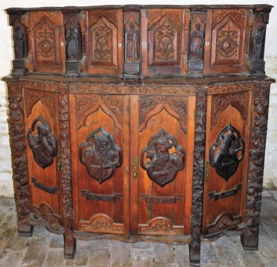 A continental oak serpentine sideboard, with various extensively carved panels doors and figures, with single key, 131cm high, 134cm wide, 62cm deep. - 2