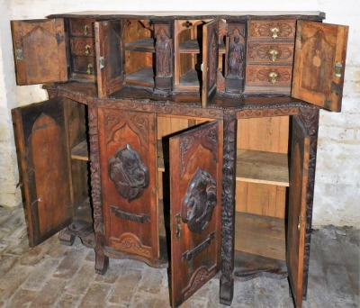 A continental oak serpentine sideboard, with various extensively carved panels doors and figures, with single key, 131cm high, 134cm wide, 62cm deep. - 3