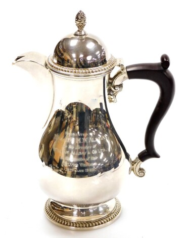 A George V silver coffee pot, with acorn finial top and rococo fluted spout, on an ebonised handle with reeded base, bearing inscription Presented to Mr & Mrs M. Wallday by the directors of William Allday and Co Ltd on the occasion of their Silver Wedding