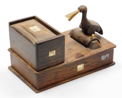 An early 20thC Japanese parquetry cigarette dispenser, with a bird picker, signed, 18cm wide.