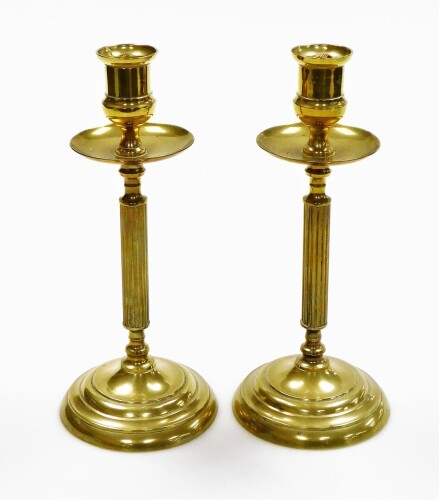 A pair of early 20thC brass candlesticks, each on a tapered column, 23.5cm high.