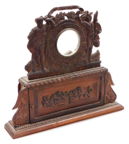 A continental carved wooden timepiece case, the top with central glass panelled section for either a clock or watch, with two gentleman to either side and a single cupboard door to base, 30cm high, 33cm wide, 6cm deep.