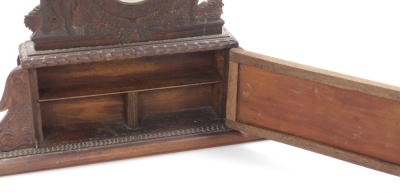 A continental carved wooden timepiece case, the top with central glass panelled section for either a clock or watch, with two gentleman to either side and a single cupboard door to base, 30cm high, 33cm wide, 6cm deep. - 3