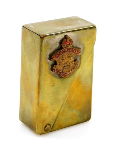 A Leicestershire military cigarette case, with applied crest for Hindoostan Leicestershire, with enamelled detailing, in a brass case, stamped Bryant and May matchbox cover, 6cm high, 4cm wide, 2cm deep.