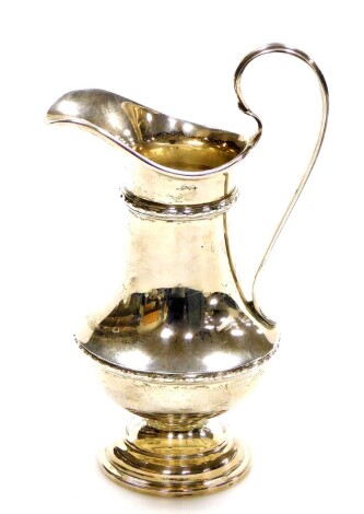 A George V silver cream jug, fluted and reeded body, on a stepped base, Birmingham 1923, 13cm high, 3¾oz.