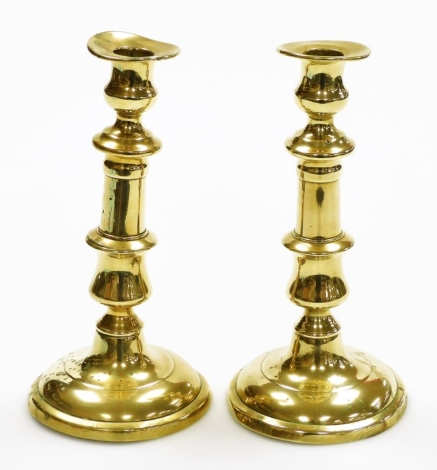 A pair of late 19thC brass candlesticks, each on a circular foot (AF), 21cm high.