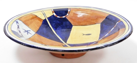 A Portuguese studio pottery bowl, with a blue ground and yellow and brown borders, 49cm diameter.