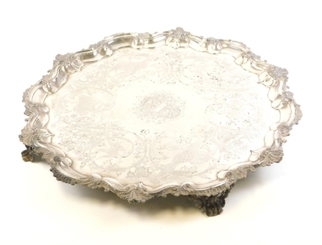 A large 19thC silver plated serving tray, the central crest of the Hodges family, with embossed Dant Lucem Crescentibus Orti with various bird and scrolls to rim on four claw feet, 69cm diameter.