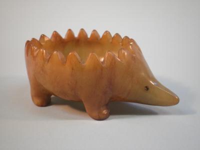 A green hardstone vessel carved in the form of a hedgehog with one glass eye