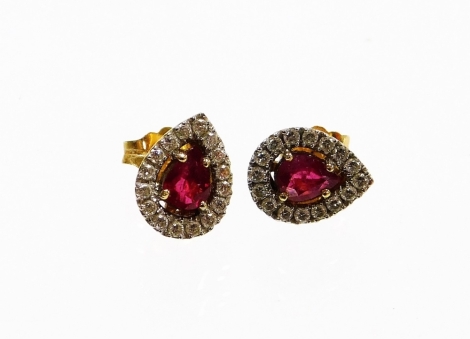 A pair of 18ct gold ruby and diamond earring, each earring set with a pear cut ruby surrounded by pavé set tiny diamonds, in a white gold setting on a yellow gold back, with butterfly backs, each earring 9mm high, 2.6g all in.