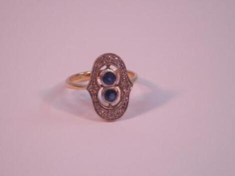 An 18ct Art Deco period plaque ring with two small round sapphires surrounded