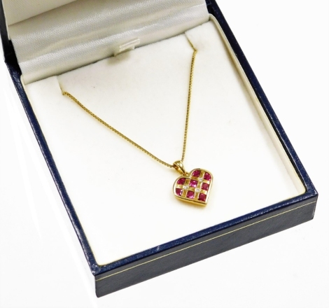 An 18ct gold ruby and diamond heart shaped pendant and chain, the heart shaped pendant set with eight square cut rubies and bordered with three tiny diamonds, on an open work back, on a fine box link chain, the pendant 1cm high, the chain 44cm long, 5g al