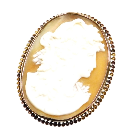 A shell cameo brooch, depicting a maiden looking dexter, the frame with rope twist border, on single pin back with safety chain, yellow metal stamped 9ct, 4.5cm x 4cm, 13.2g all in, boxed.