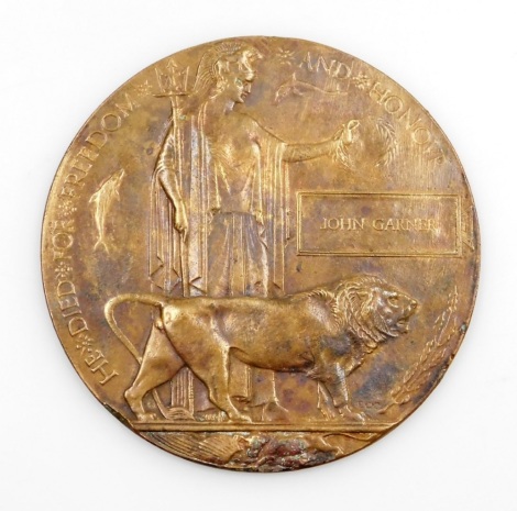 A World War I death plaque, presented to John Garner, 12cm diameter.