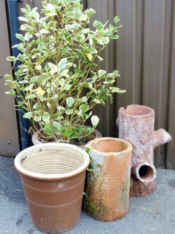 Four garden planters, to include a brown circular garden planter with ivy tree, 40cm high, a further brown pot, 43cm high, a terracotta tree trunk planter, 60cm high and a terracotta part chimney pot, 46cm high. (4)