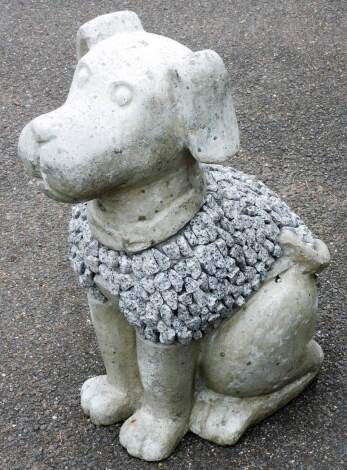 A reconstituted stone garden ornament of a dog, with a side pebble decoration, 60cm high.