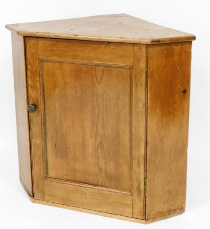 A Georgian pine hanging corner cabinet, with arched top on single door with a brass handle, 82cm high, 90cm wide at the widest point, 59cm deep at the widest point.