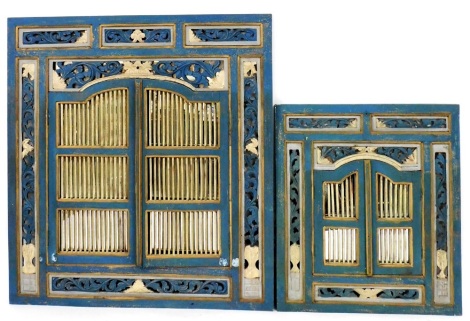 Two painted wooden wall mirrors, each of similar design with a carved fleur de lys border central rectangular mirror glass panel with arched and reeded opening doors painted in cream and blue, on a mahogany back, 130cm high, 120cm wide, 3cm deep, with sma