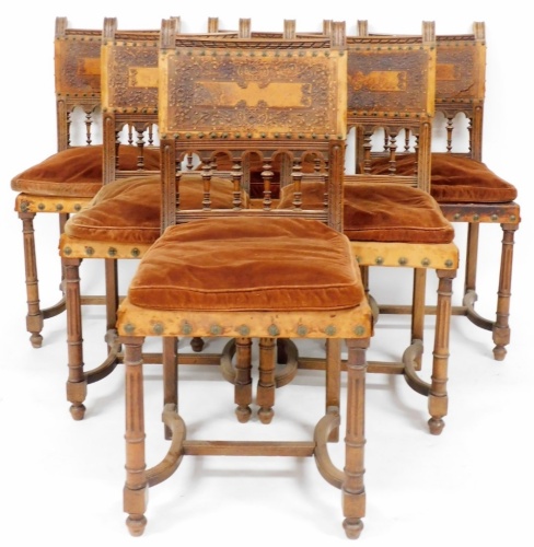 A set of six 19thC carved oak and embossed leather dining chairs, the back panel each inset with a leather depiction of flowers and leaves, with buttoning details, on pillar columns with cushion seats on tapered legs, 95cm high, 44cm wide, 42cm deep.