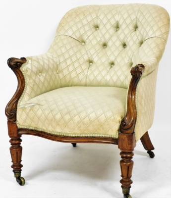 A Victorian button back armchair, the shaped mahogany front, with carved panelling on castors, on a tilted back with a cream and green chequered upholstery, 86cm high, 61cm wide, 72cm deep.