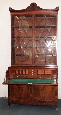 A George III mahogany secretaire bookcase, with a stepped arch pediment with satinwood stringing, flame frieze over two tall hour glass and diamond shaped astragal doors, the fall front secretaire drawer having satinwood and ebony stringing with flamed ca - 2