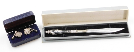 A pair of oriental silver cuff links, the crested shield bearing Chinese symbols, together with a three piece silver letter opener, each boxed. (2)