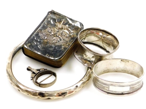 A small group of silver and other wares, to include two silver napkin rings, a silver bangle, a silver swivel fob frame, 1½oz and a silver fronted miniature common prayer book. (5)